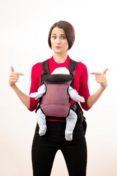 confused young mother with her baby in wrong sling. Isolated on white.