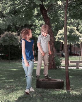 little brother and sister standing on the Playground. city life