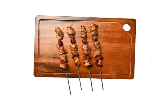 Cutting board with grilled chicken meat isolated on white background.