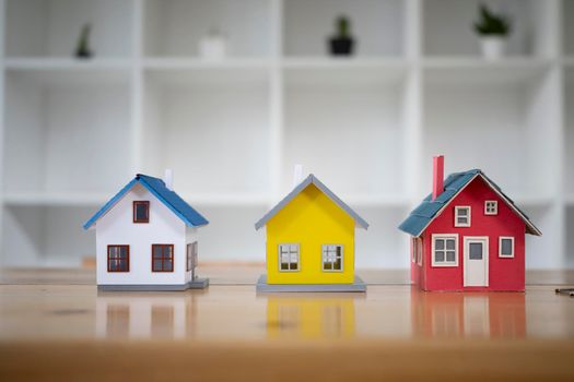 Three small house model on an architects table. New house, insurance and real estate concept.
