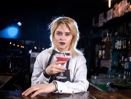 Girl bartender mixes a cocktail in the beerhouse
