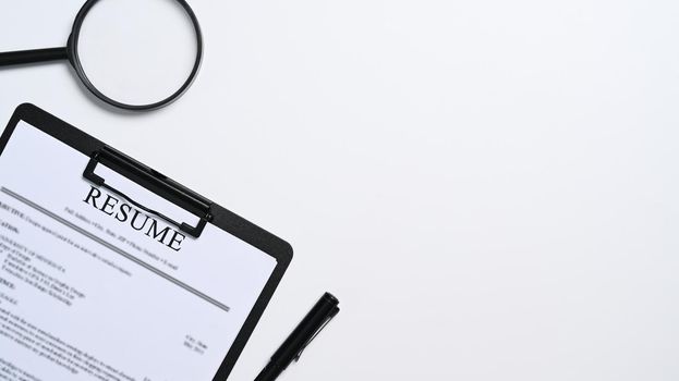 Resumes of applicants and magnifying glass on white background. Job search concept.