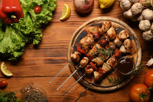 Barbecue, chicken kebab with vegetables on wooden background. Top view, Flat lay.