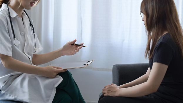 Female doctor explaining medical treatment to her patient. Healthcare and medical concept.