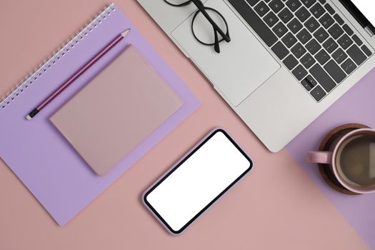 Modern feminine workplace concept. Computer laptop, smart phone, coffee cup and notebook. Flat lay.