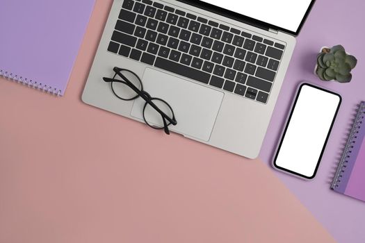 Feminine workplace with laptop computer, smart phone, notebook and glasses. Top view.