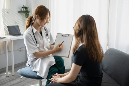 Focused female doctor in white uniform giving professional consultation to patient. Healthcare and medical concept.