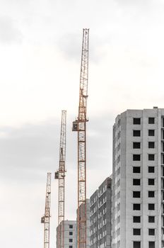 Three Construction crane on a cloudy sky.