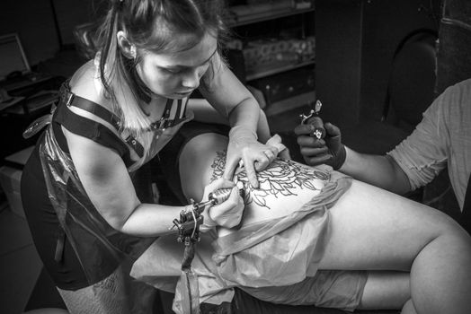 Professional tattooist showing process of making a tattoo.