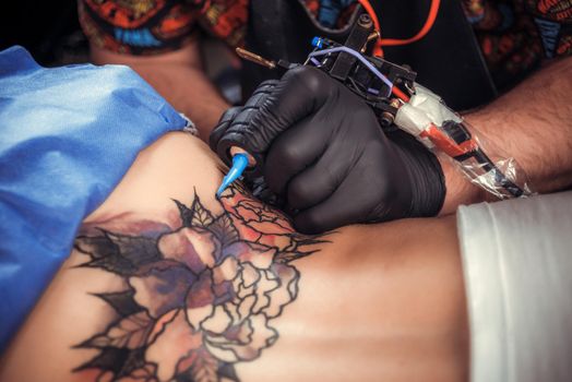 Tattooer creates a tattoo.