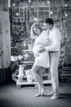 photo in retro style. loving husband looking at his pregnant wife's tummy. the concept of parenthood