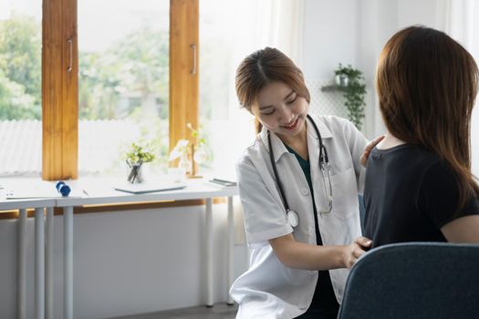 Female physiotherapist examining back of female patient in rehabilitation clinic. Physical therapy concept.