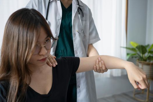 Female patient is exercising treatment with physiotherapist after arm injury. Rehabilitation physiotherapy concept.