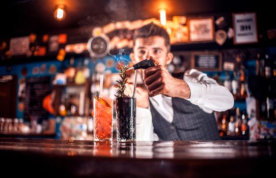 Barman concocts a cocktail on the bar