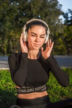 Pretty girl listening to music by earphone./Athletic girl lying and relaxing with headphones.