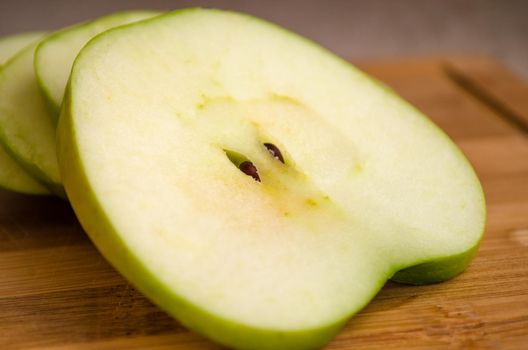 sliced green apple on wooden cutting board