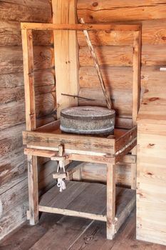 Retro millstone in old wooden house.