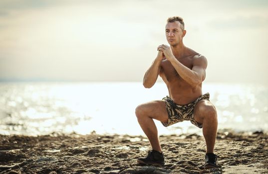 A handsome man ais doing stretching exercise at the sea beach in summer sunny day.