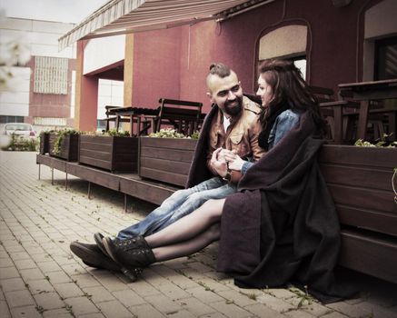 Beautiful sexy young couple sitting on the terrace in a cozy cafe