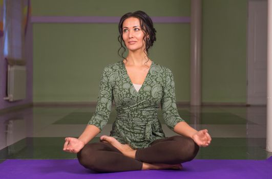 Professional yoga trainer demonstrates yoga positions ./Yoga trainer working yoga stretches in a studio.