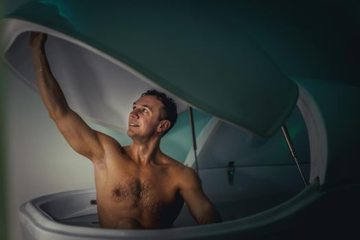 Relaxed man is floating in a sensory deprivation tank. He is very relaxed. Wellness and Spa concept.
