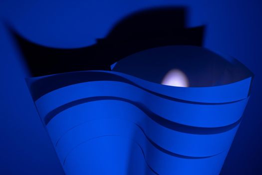 Abstract art. Blue paper waves with backlight and contrasting shadow. Abstract design. Handmade.