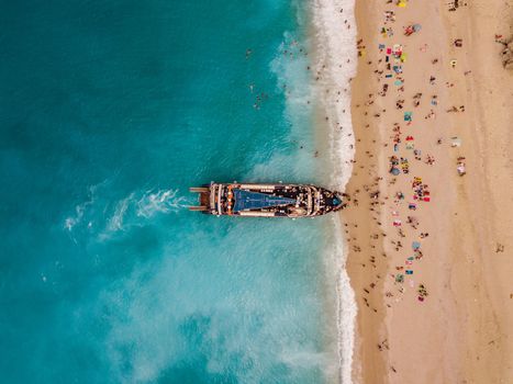 Aerial view from drone of amazing azure beach with rocky mountains and clear turquoise water of Mediterranean sea at sunny day. Tourist boats anchoring on the Egremni beach on Greek island Lefkada.