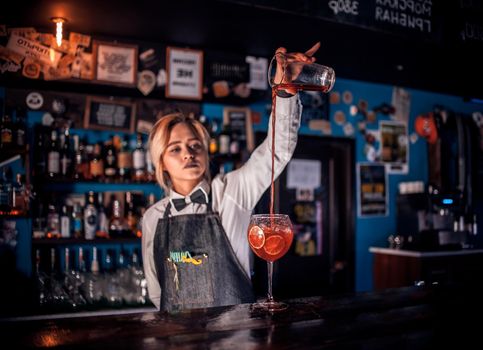 Girl bartender makes a cocktail on the beerhouse