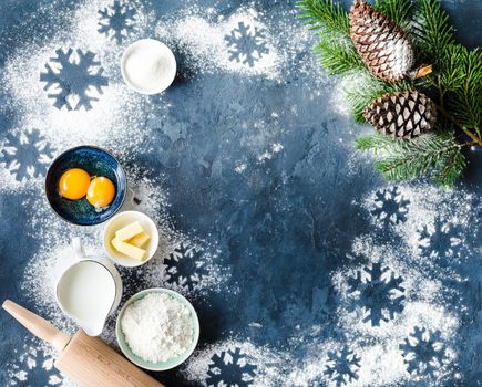 Christmas/New Year food background. Baking ingredients, cooking utensils, Christmas decoration. Making festive New Year sweets/cookies. Flour, rolling pin, milk, eggs, sugar. Top view. Holidays