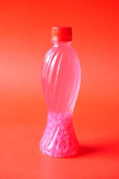 plastic bottles of soft drink on red background .