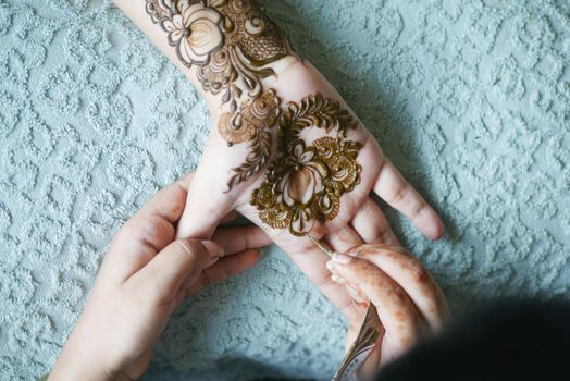 women applying henna on hand .