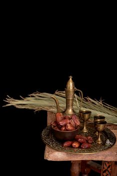 Ramadan Kareem Festive, close up of dates on wooden plate and rosary with oriental Lantern lamps and cup of black tea on wood background. Islamic Holy Month Greeting Card