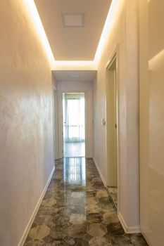 new home corridor with an open door at the end and ceramic tiles