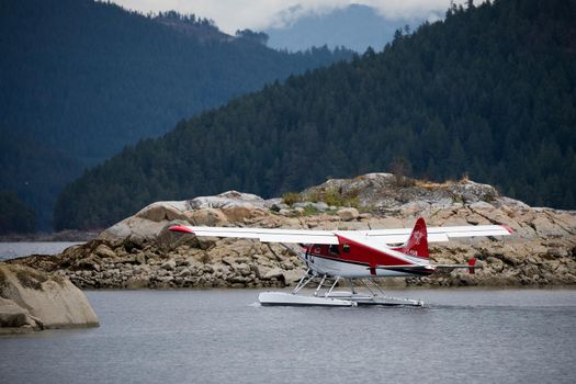 White and red Dehavilland Beaver float plane going through a cut in an an island before take-off. Ballet Bay, British Columbia
