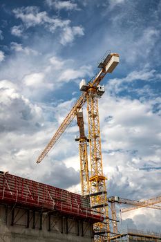 Day view of the construction site with cranes and building. Vertical view