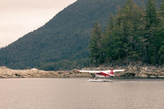 White and red Dehavilland Beaver float plane going through a cut in an an island before take-off. Ballet Bay, British Columbia