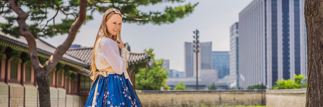 Young caucasian female tourist in hanbok national korean dress. Travel to Korea concept. National Korean clothing. Entertainment for tourists - trying on national Korean clothing. BANNER, LONG FORMAT