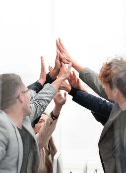 close up. a group of happy employees giving each other a high five.