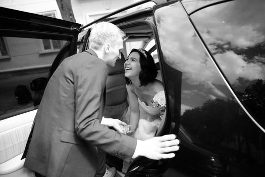 black-and-white photo .happy couple talking near wedding limo.holidays and events