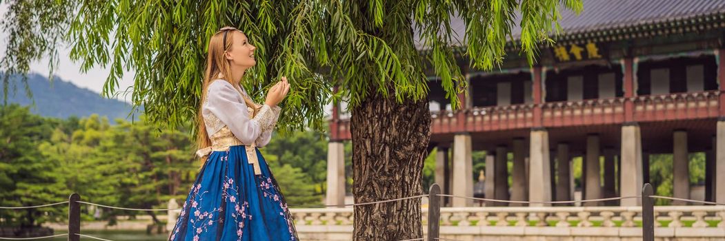 Young caucasian female tourist in hanbok national korean dress. Travel to Korea concept. National Korean clothing. Entertainment for tourists - trying on national Korean clothing. BANNER, LONG FORMAT