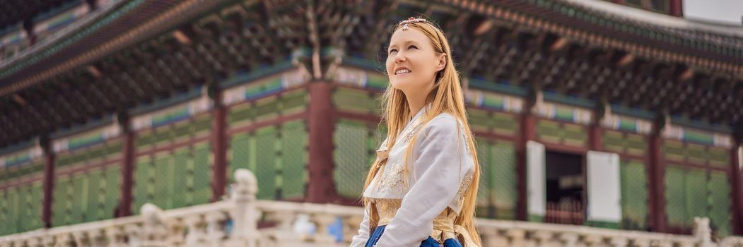 Young caucasian female tourist in hanbok national korean dress. Travel to Korea concept. National Korean clothing. Entertainment for tourists - trying on national Korean clothing. BANNER, LONG FORMAT