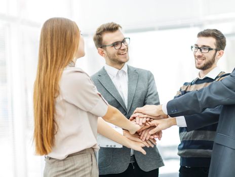 friendly business team standing in a circle and joining his hands together