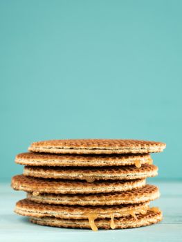 Stroopwafels or caramel Dutch Waffle close up on turquoise wooden background