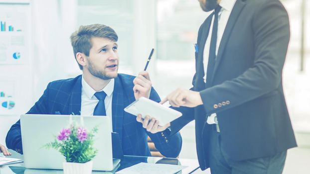 business partners discuss the profits before signing the contract in the workplace in a modern office.the photo has a empty space for your text