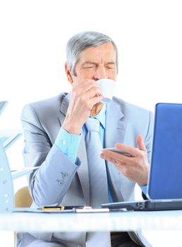 The businessman at the age of drinking coffee during the break. Isolated on a white background.
