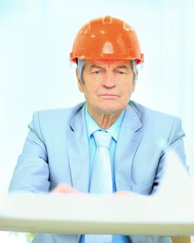 Engineer at the age of considering plans drawing and corrects them.