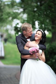 Happy young bride and groom outside on their wedding day. Wedding couple - new family