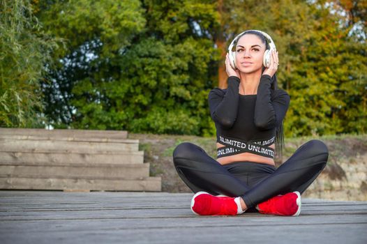 Pretty young woman listens to music ./Fitness woman listening to music with headphones.