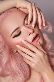Beautiful Woman with Curly Colored Hairstyle and Fashion Make-up. Beauty Soft-Girl Style with Tender Pink Hair, Yellow French Manicure, Spring Makeup. Valentines Day, March 8 or Womens Day Look