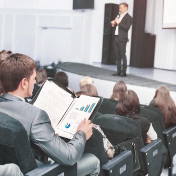 Speaker at a business convention and presentations. The audience sitting businessman and analyzes done by the report and prepares for performance